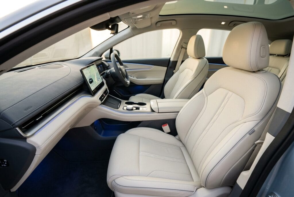 Premium automotive PU leather upholstery for electric vehicle interior with cream perforated seats and grey dashboard